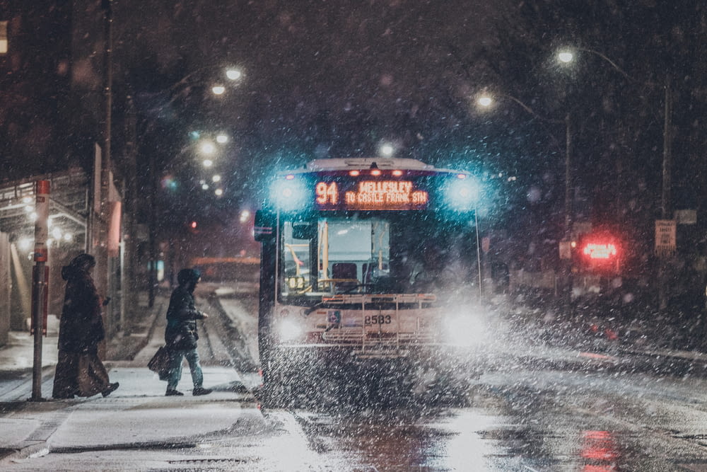 a city bus driving down a snow covered street
