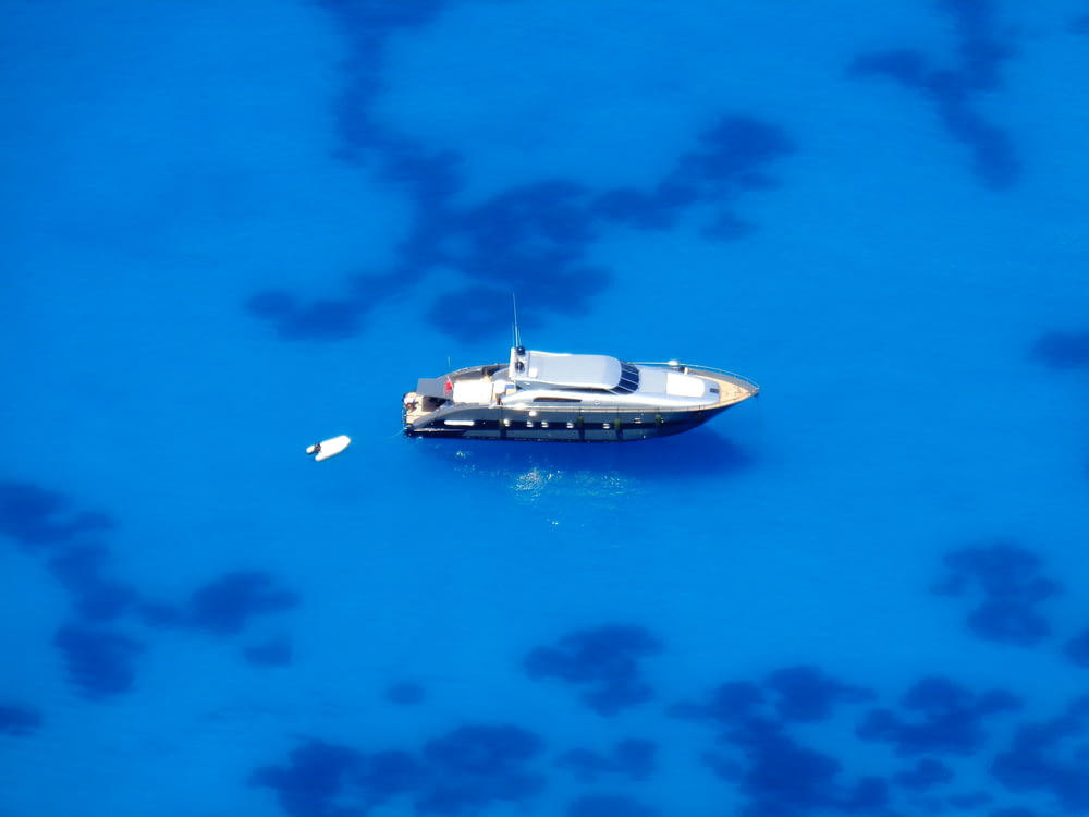 a small boat floating on top of a blue ocean