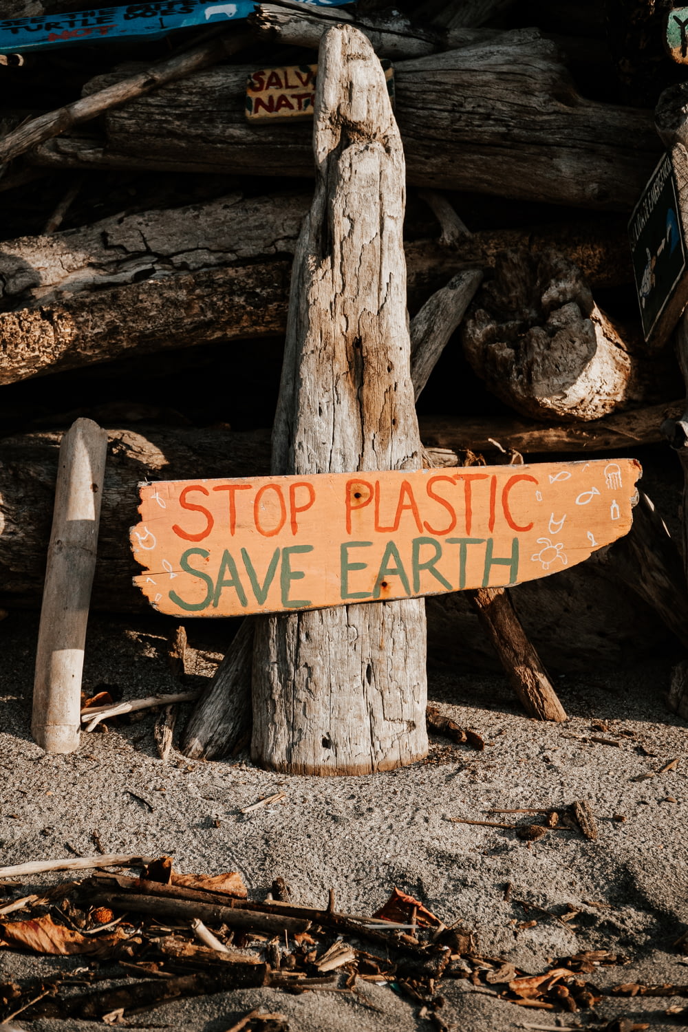a wooden sign that says stop plastic save earth