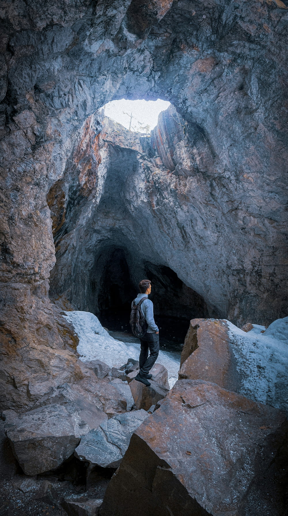 a man standing in a cave with a backpack
