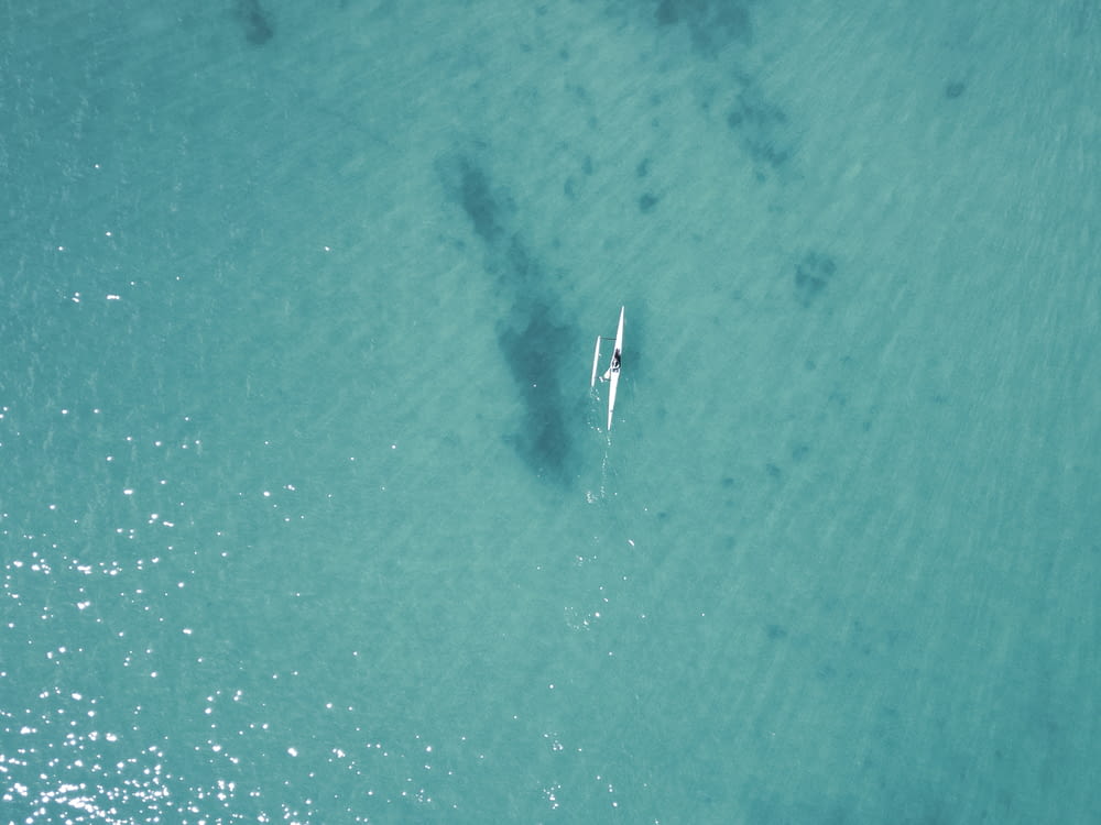 an aerial view of a person on a surfboard in the ocean