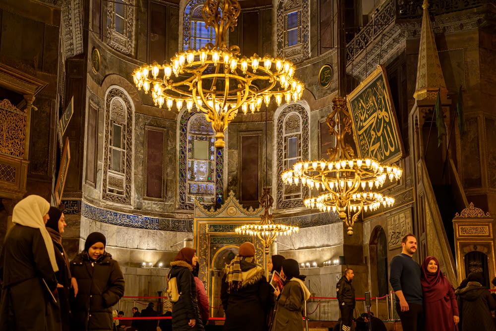 a group of people standing in front of a chandelier