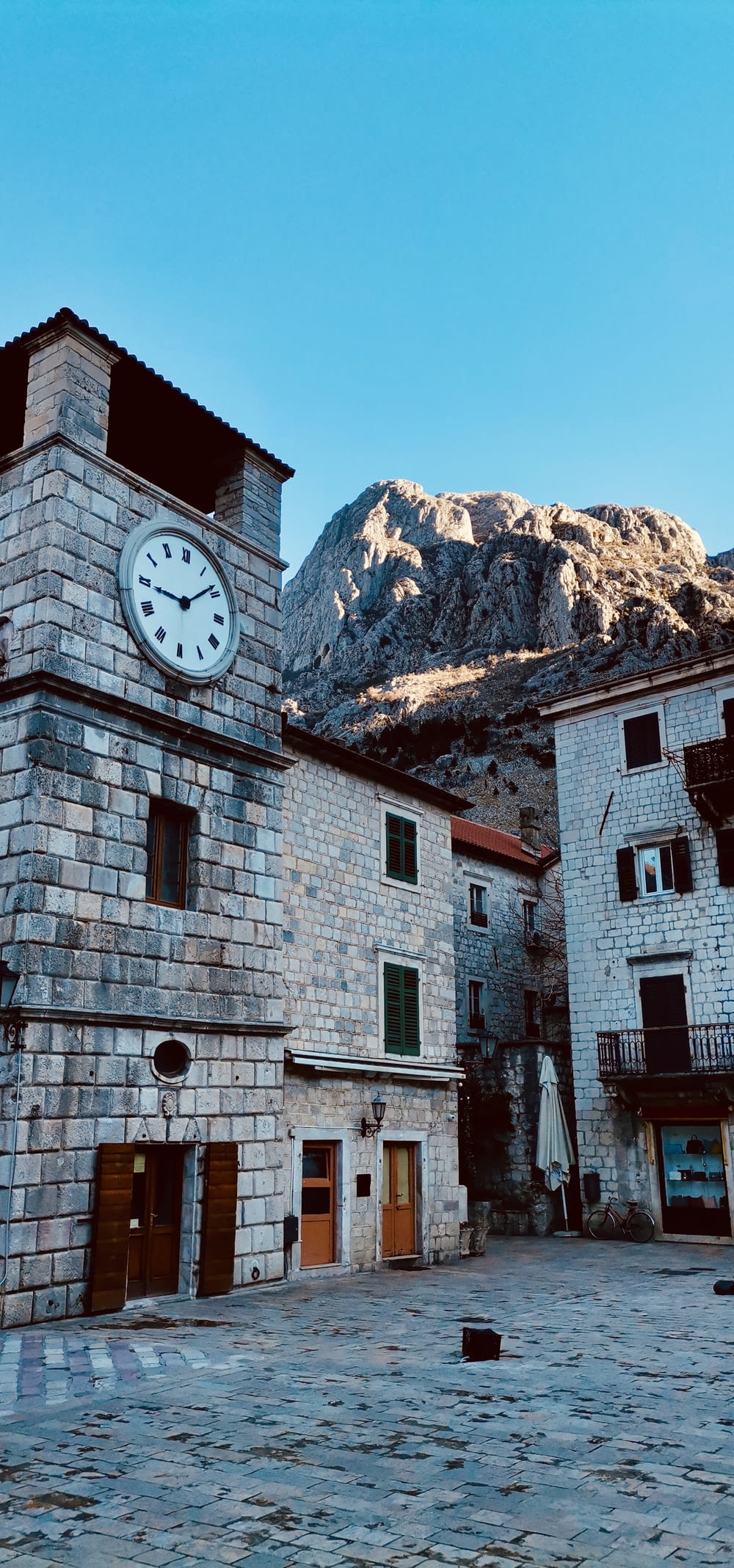 a stone building with a clock on the side of it