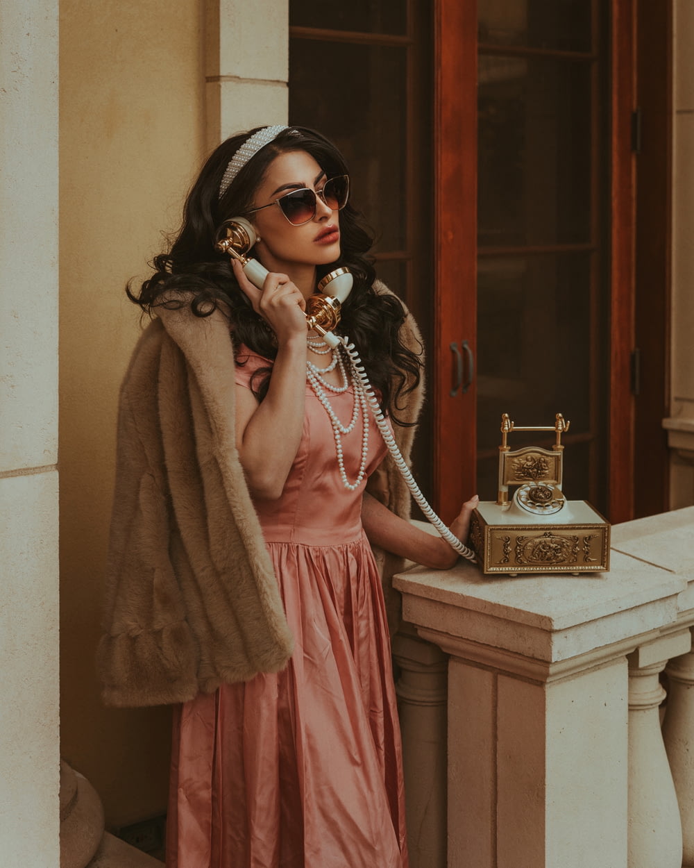 a woman in a pink dress talking on a phone