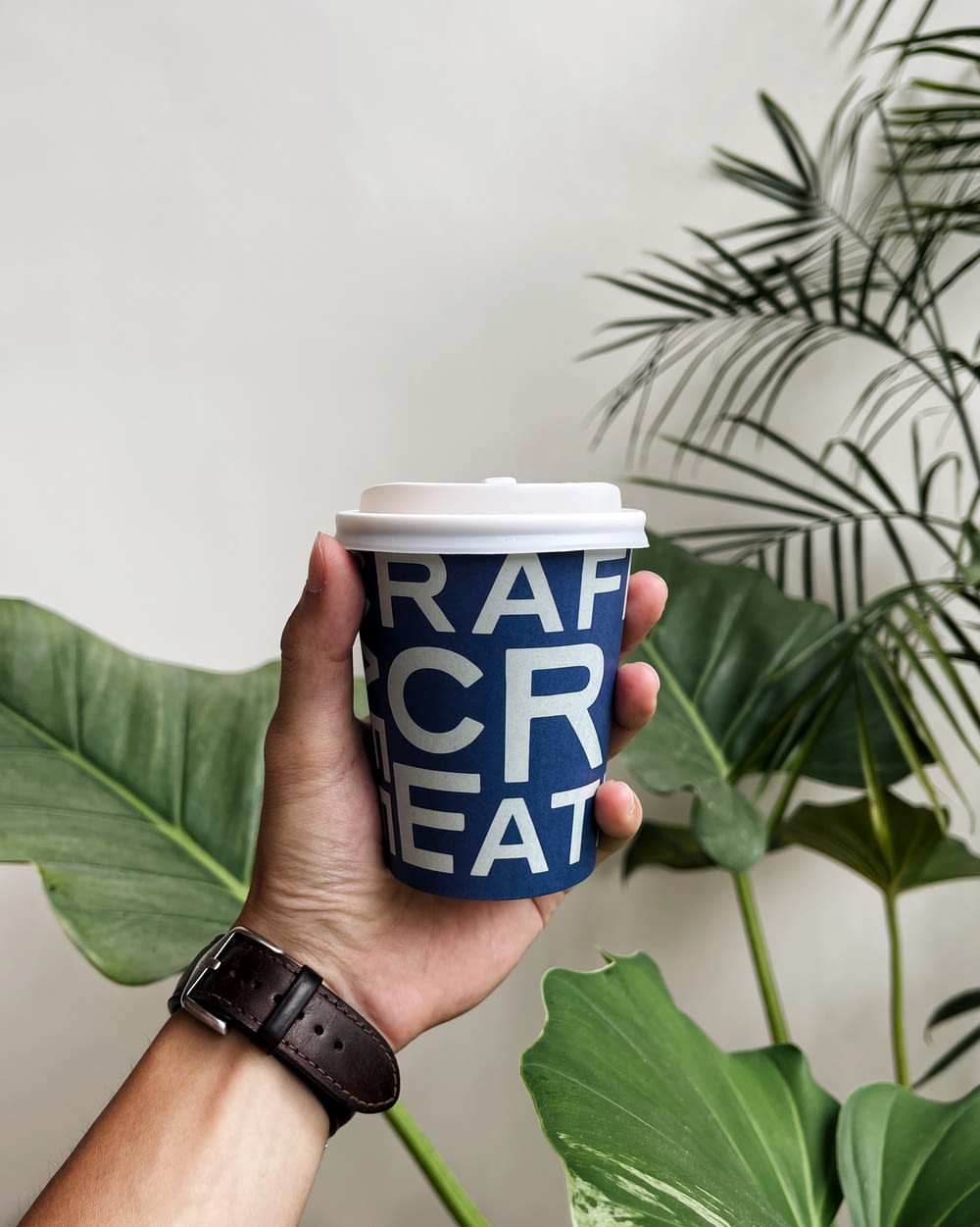 a hand holding a coffee cup with the words rah creat on it
