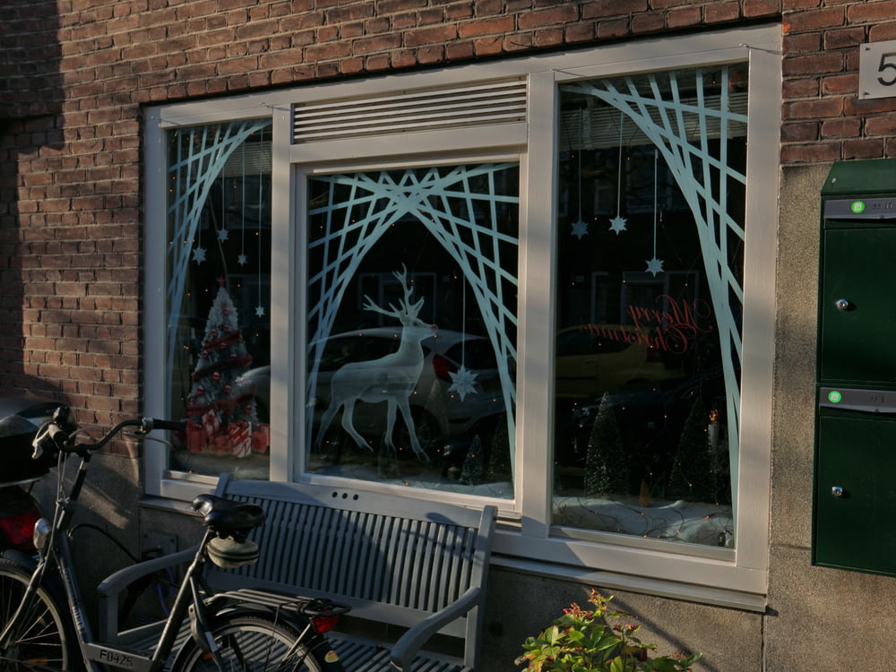 창문이 있는 건물 옆에 주차된 자전거