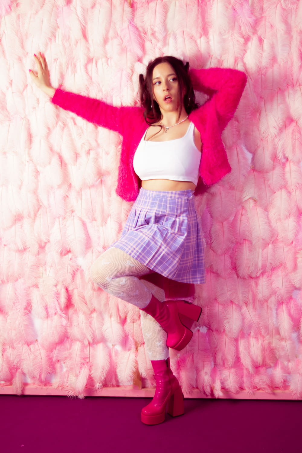 a woman in a skirt and pink jacket posing for a picture