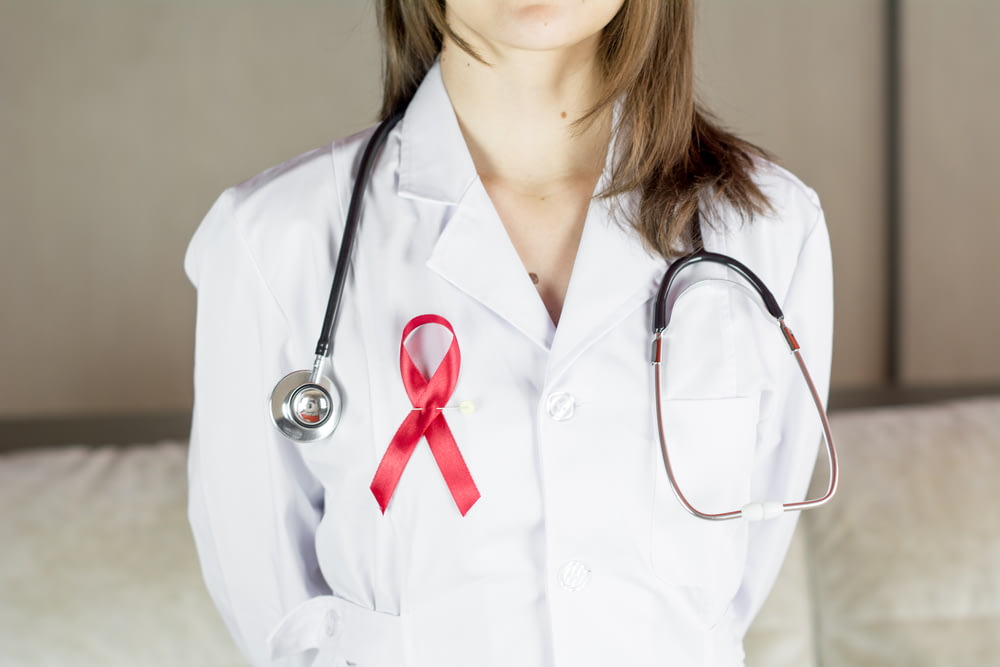 a female doctor wearing a red ribbon and a stethoscope