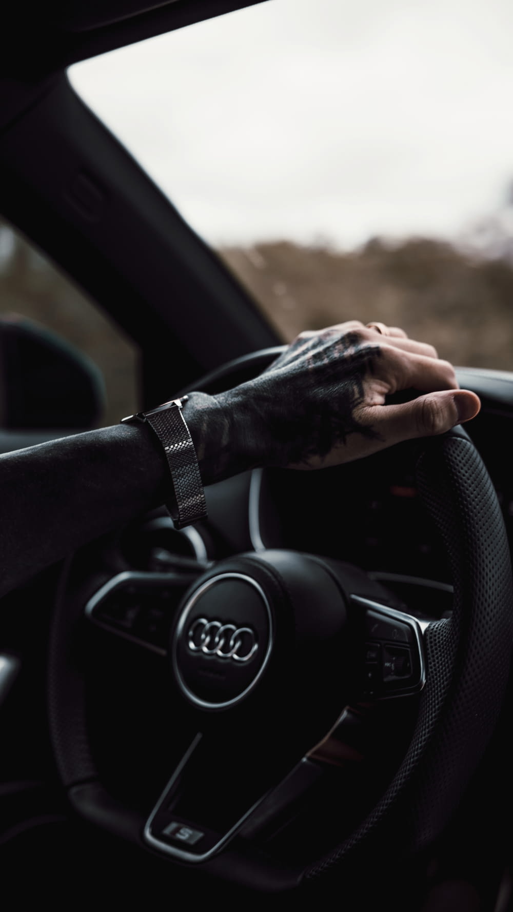 a person's hand on the steering wheel of a car