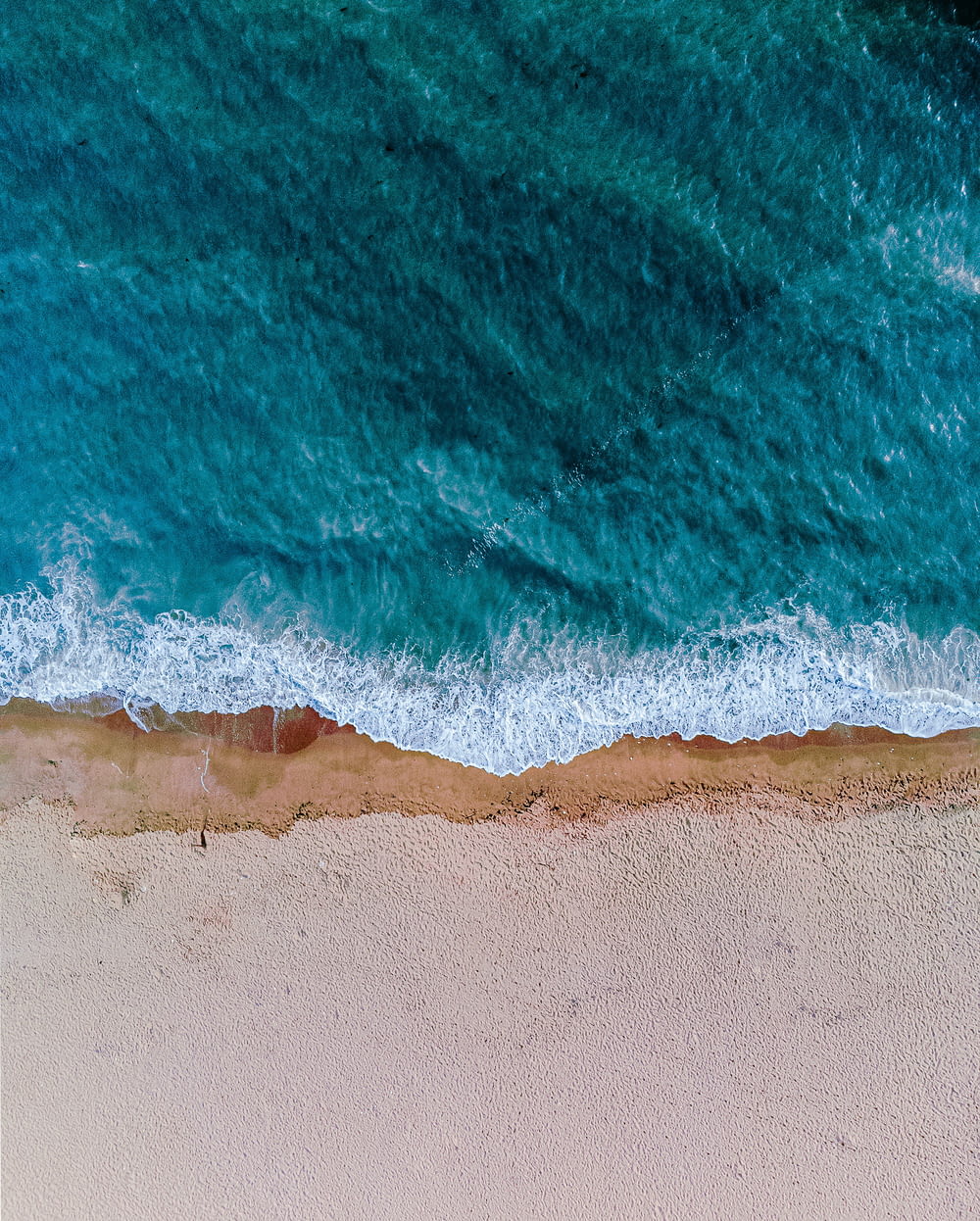 an aerial view of a sandy beach and ocean