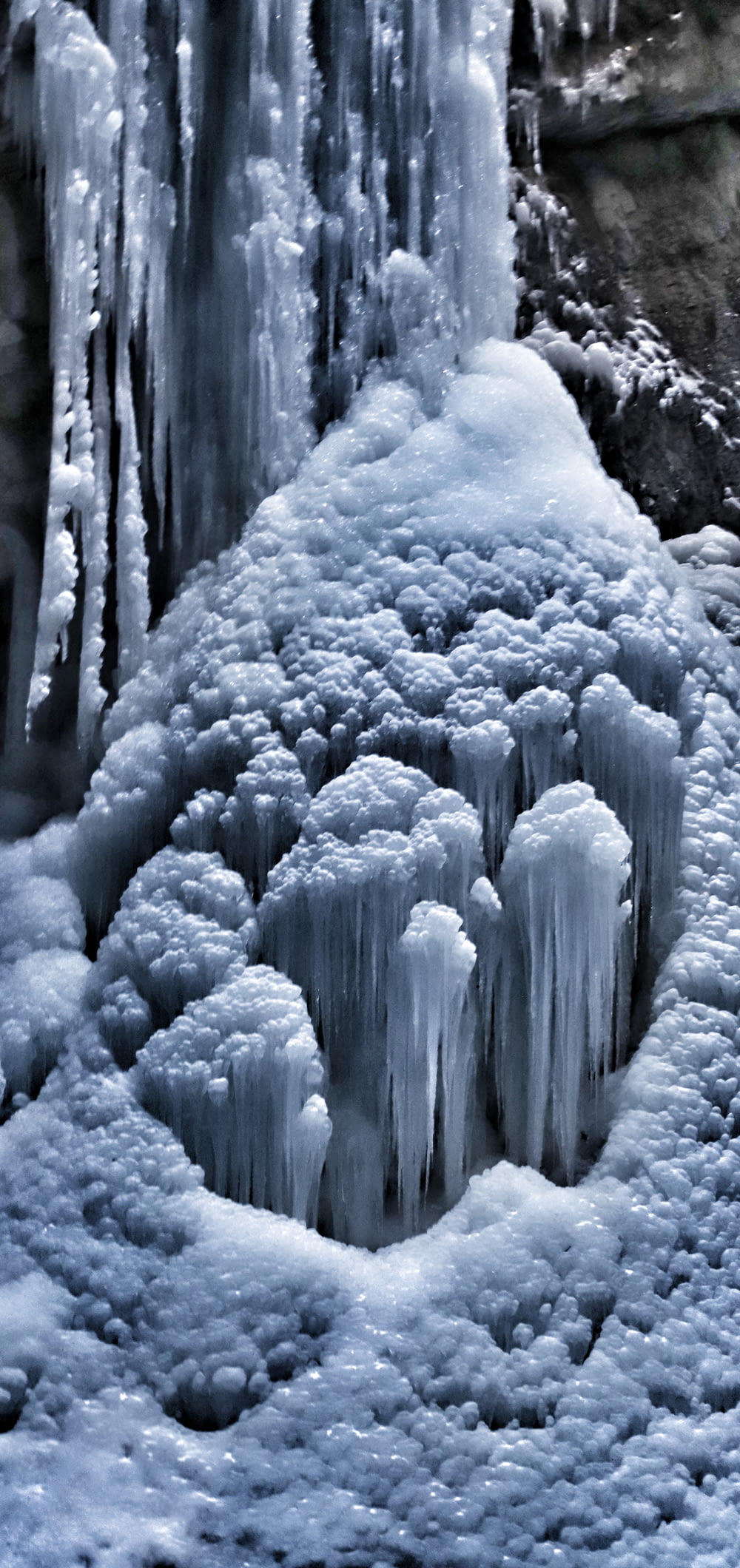 Eine Gruppe von Eiszapfen, die sich neben einem Wasserfall befinden