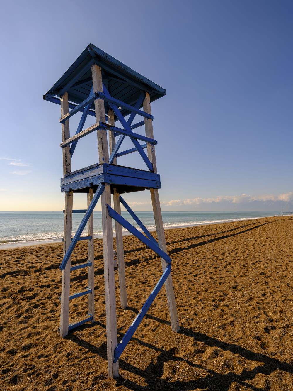 a lifeguard tower on a beach with the ocean in the background