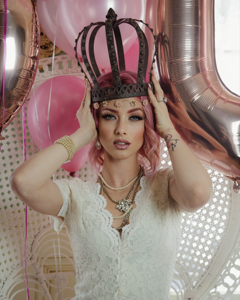 uma mulher com cabelo cor-de-rosa que usa uma coroa
