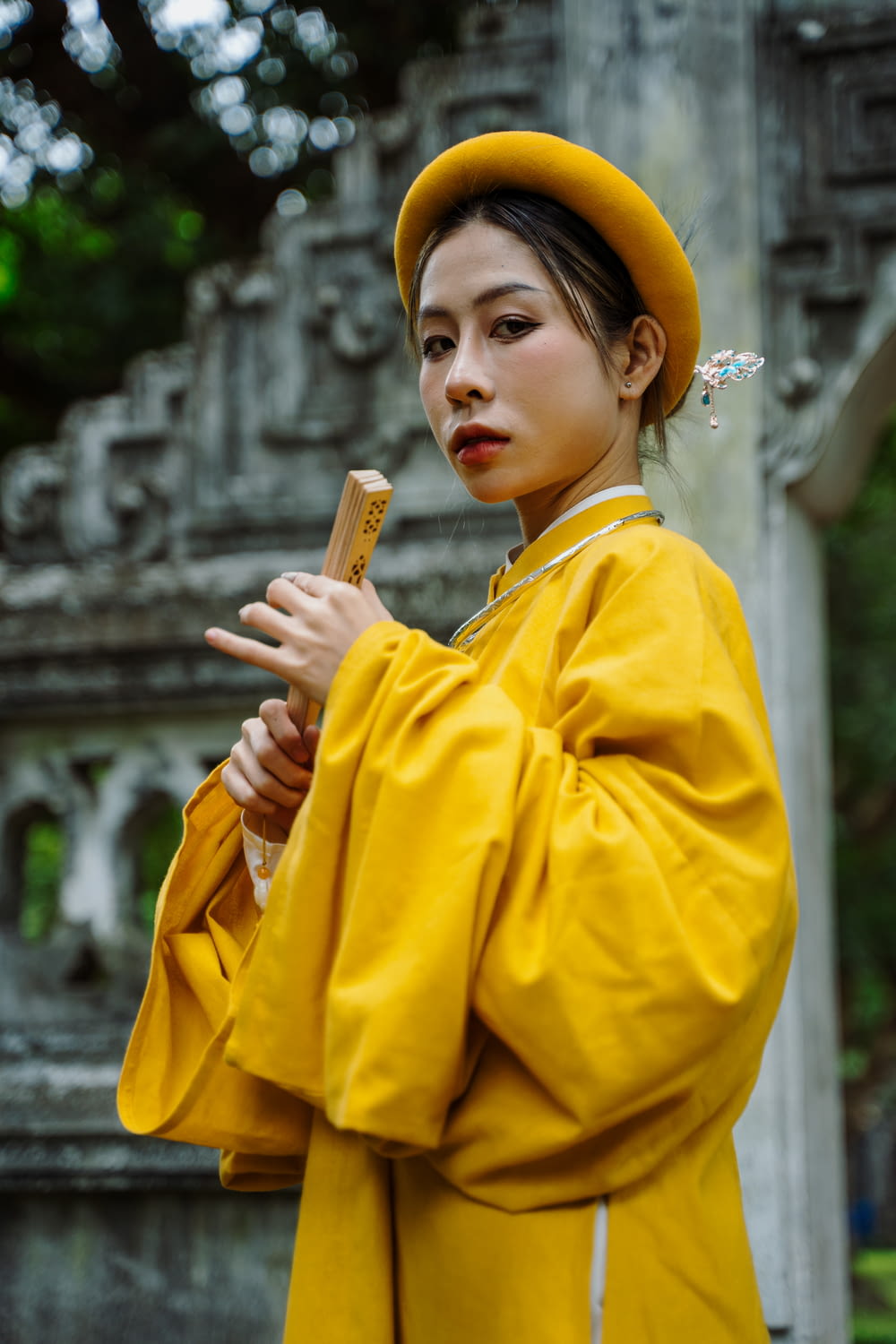 a woman in a yellow outfit holding a stick