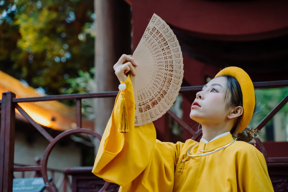 a woman in a yellow outfit holding a parasol