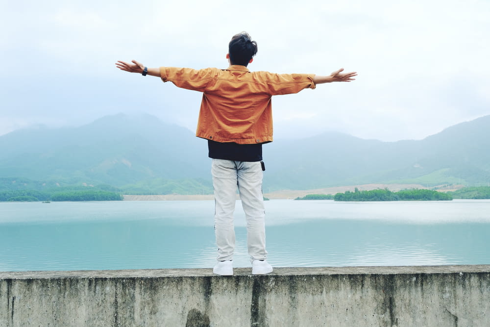 a man standing on a wall with his arms outstretched