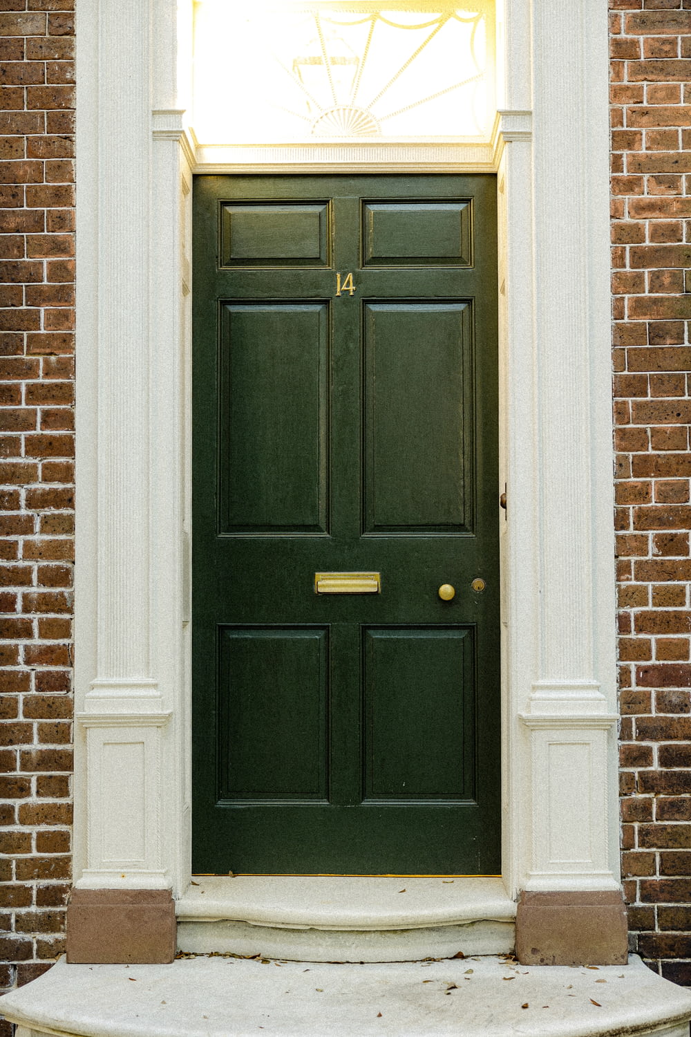 a green front door on a brick building