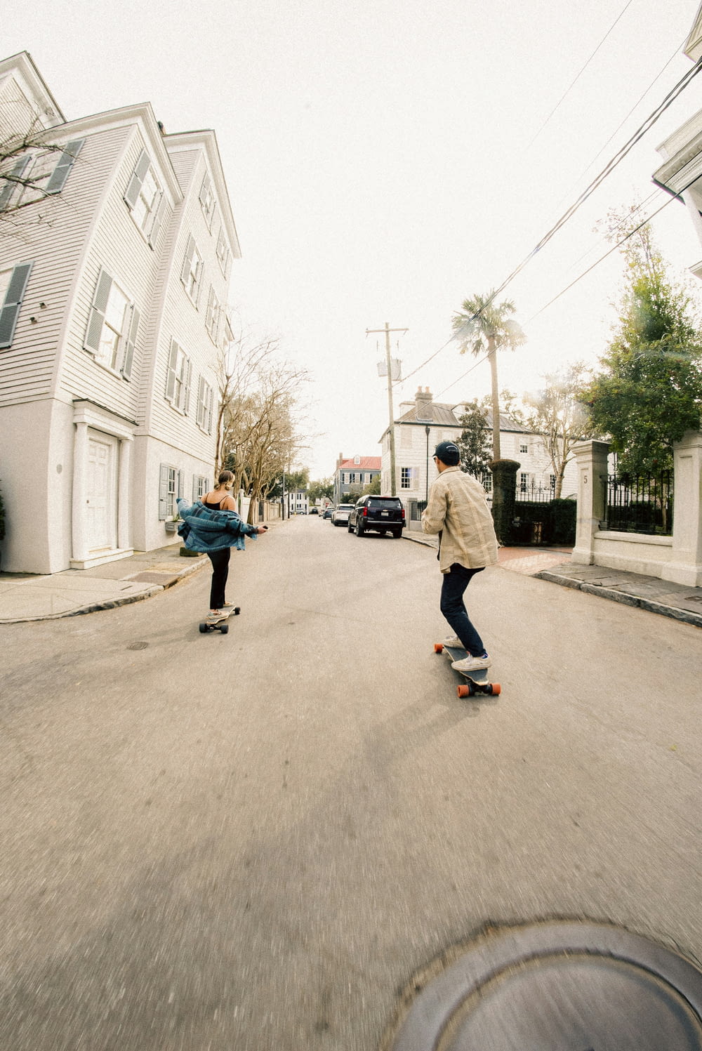 a couple of people riding skateboards down a street
