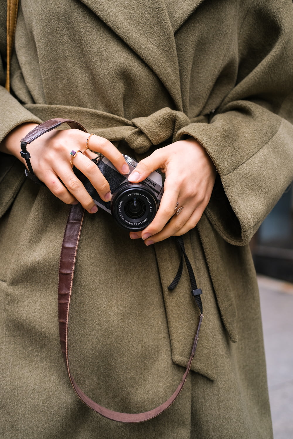 a woman in a coat holding a camera