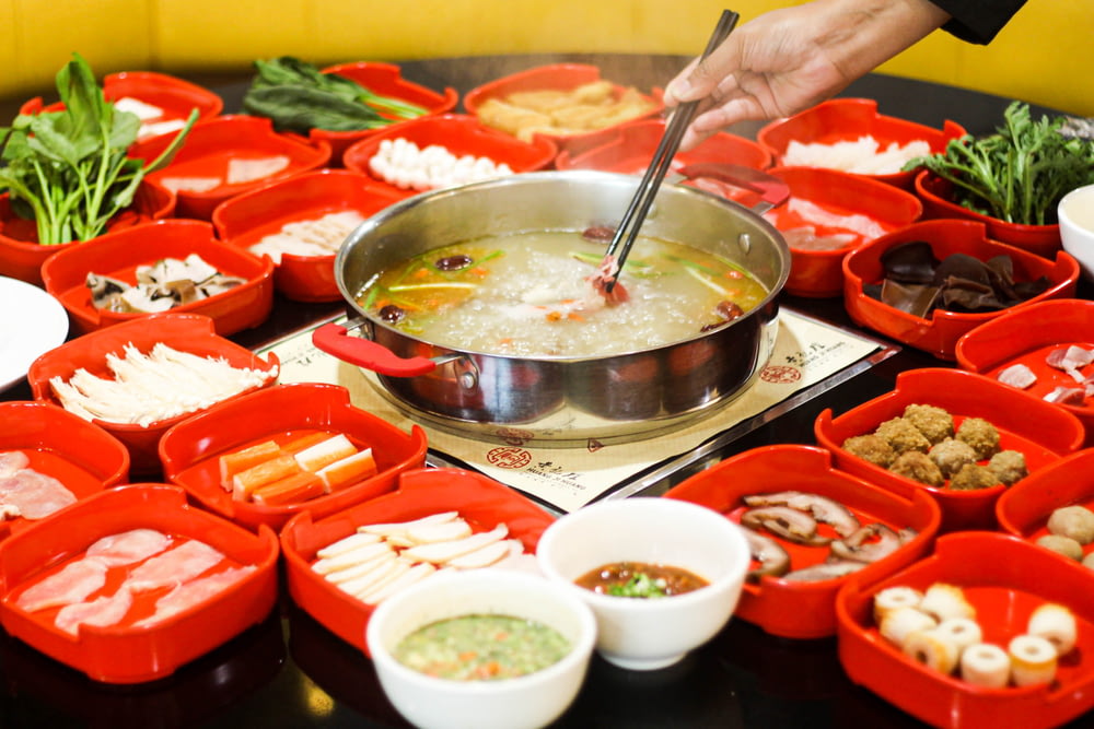 a bowl of soup is being served with chopsticks
