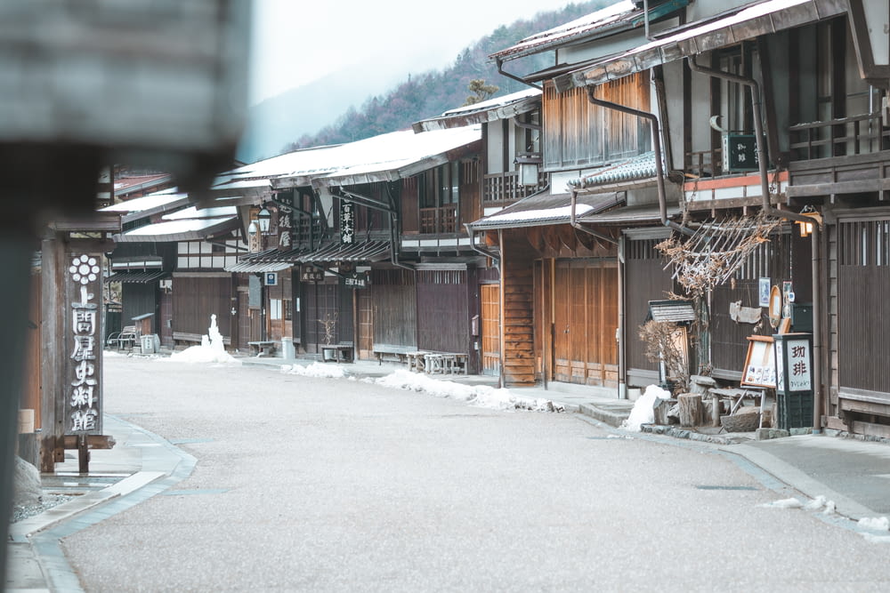 a street lined with wooden buildings covered in snow