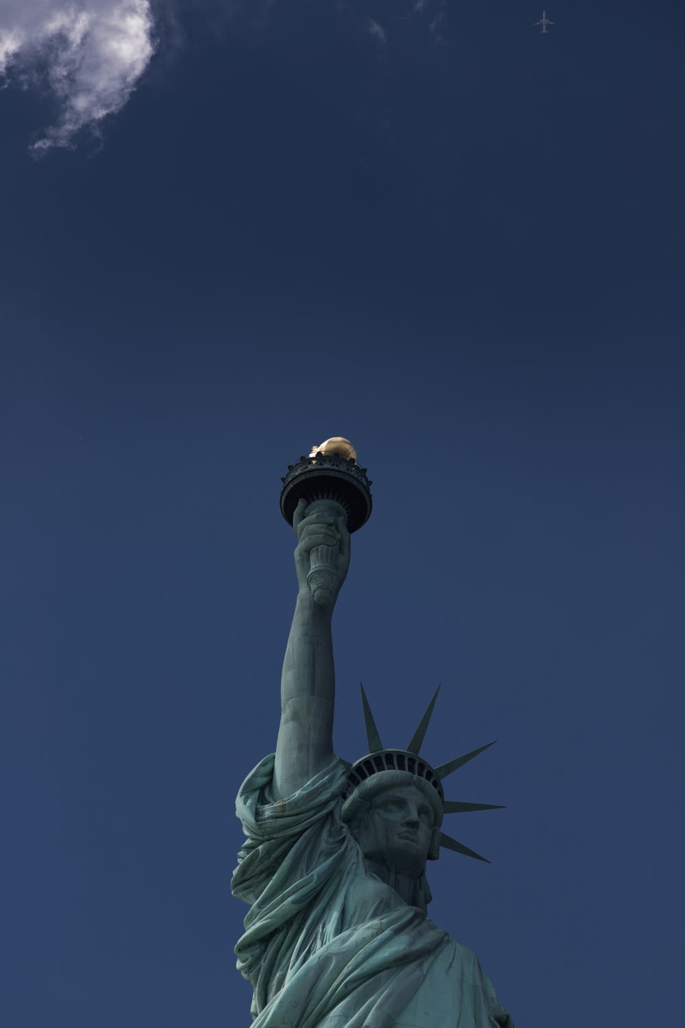 the statue of liberty under a cloudy blue sky