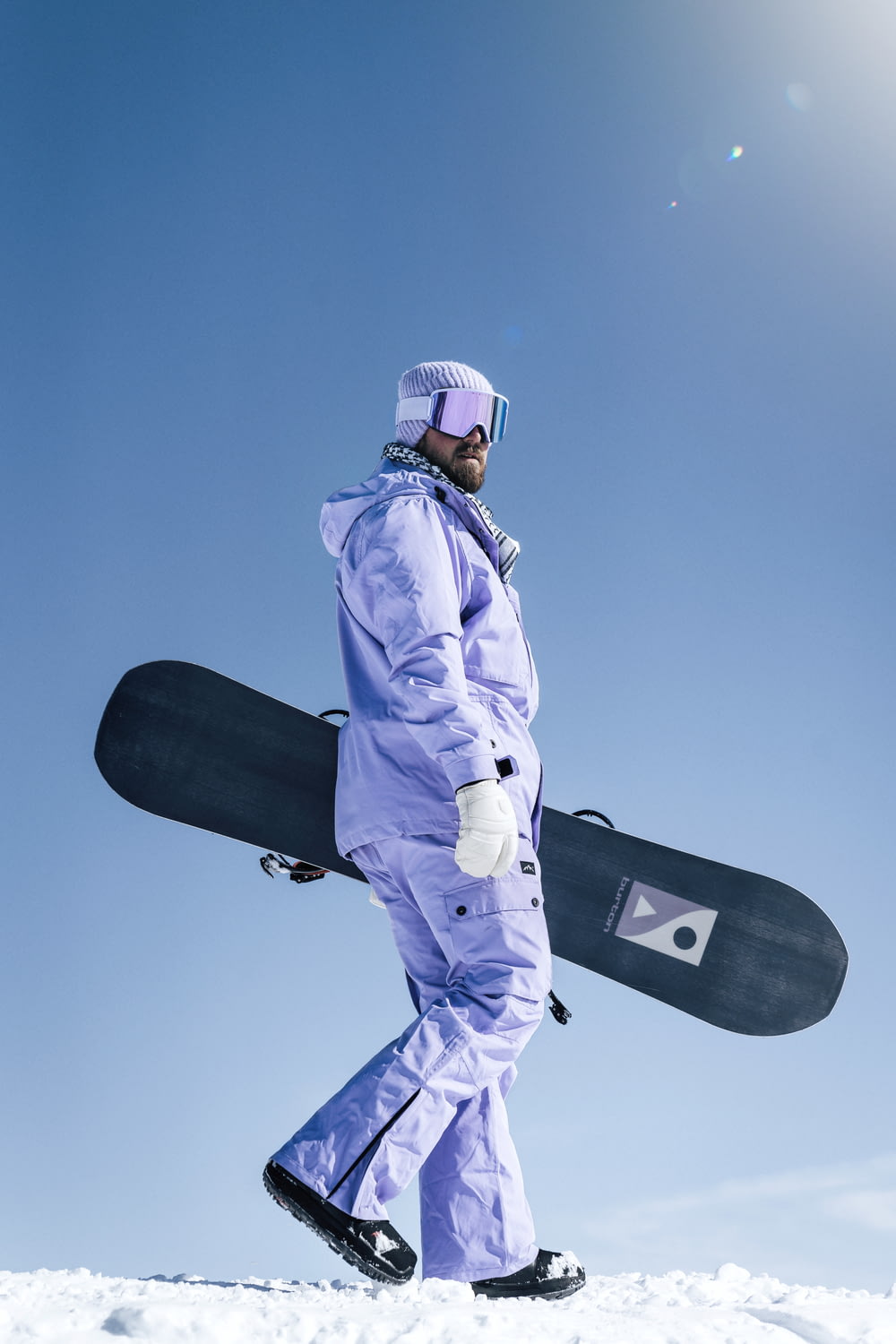 Un uomo che cammina nella neve con uno snowboard