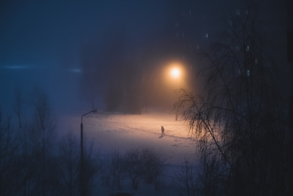 a person walking in the snow at night