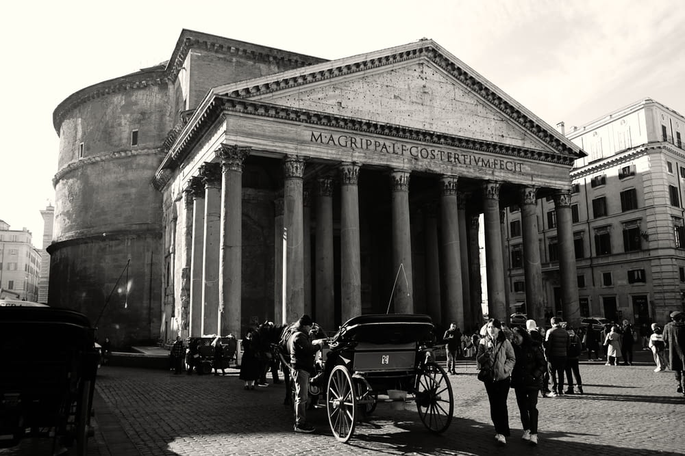 a black and white photo of a horse and carriage in front of a building