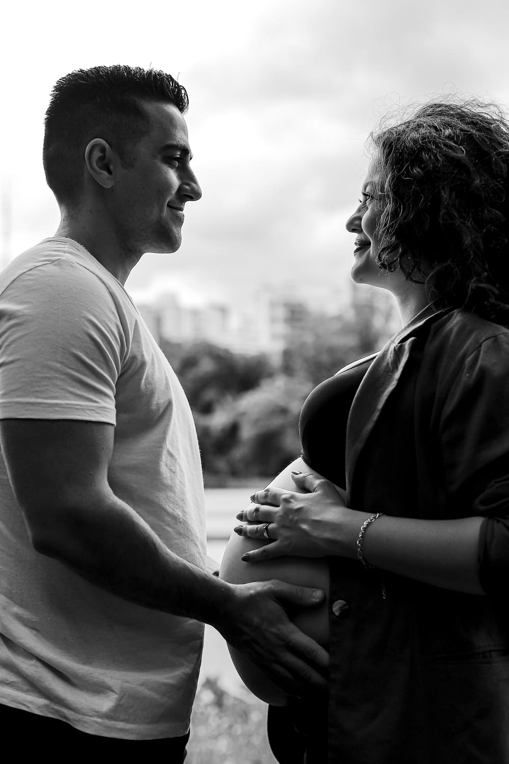 a black and white photo of a pregnant couple