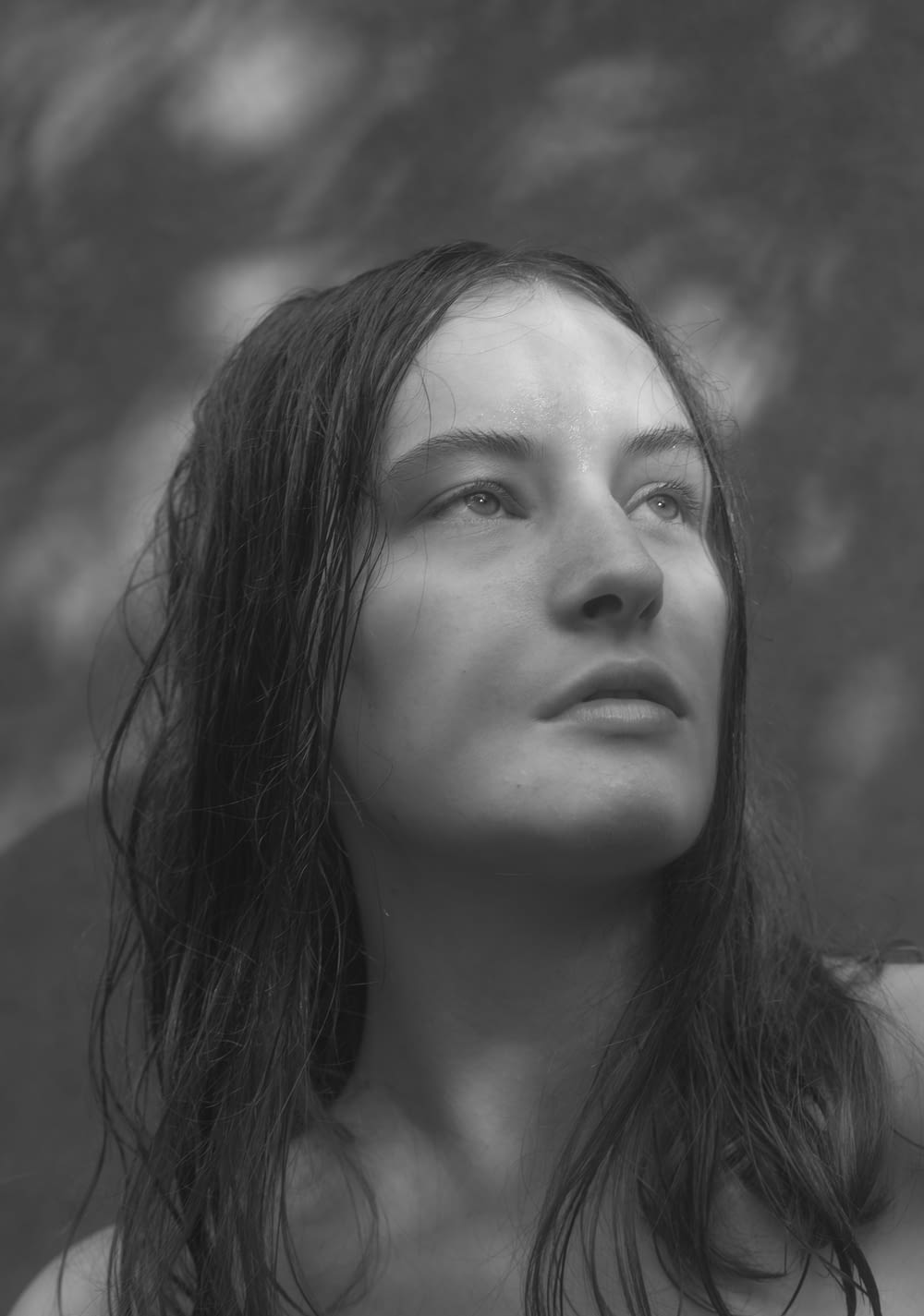 a black and white photo of a woman with wet hair