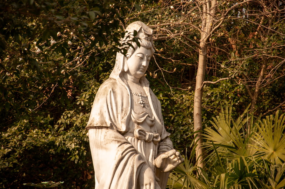 a statue of a person with a tree in the background