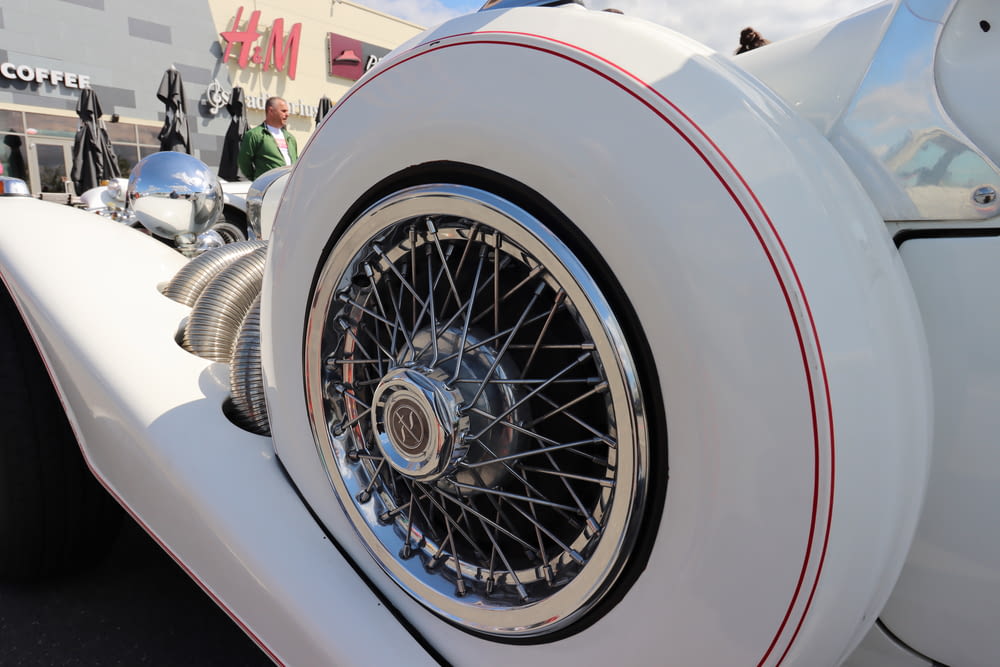 a close up of a white motorcycle with chrome spokes