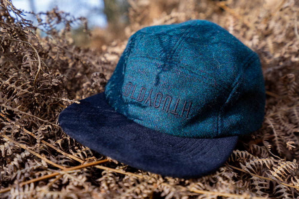 a blue hat sitting on top of dry grass