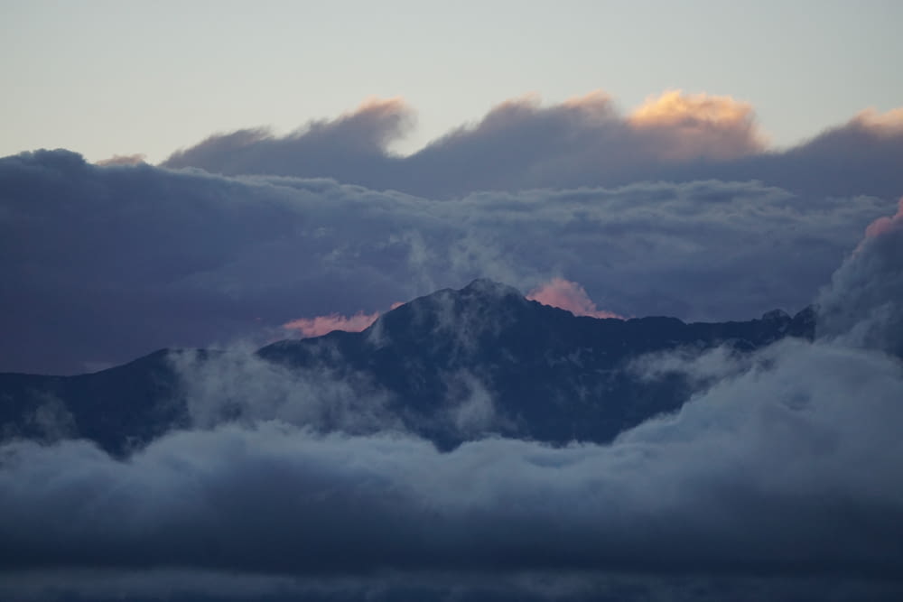 a view of a mountain covered in clouds