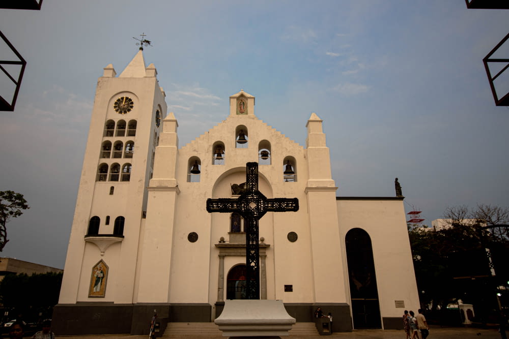 Una gran iglesia blanca con una cruz frente a ella