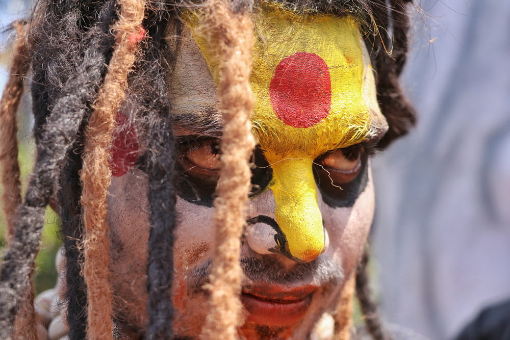 a close up of a person with a clown face painted on