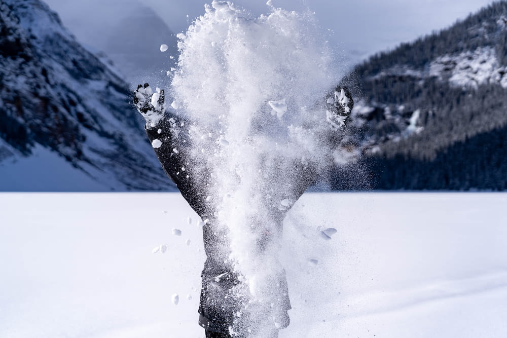 a person standing in the snow with their feet in the air