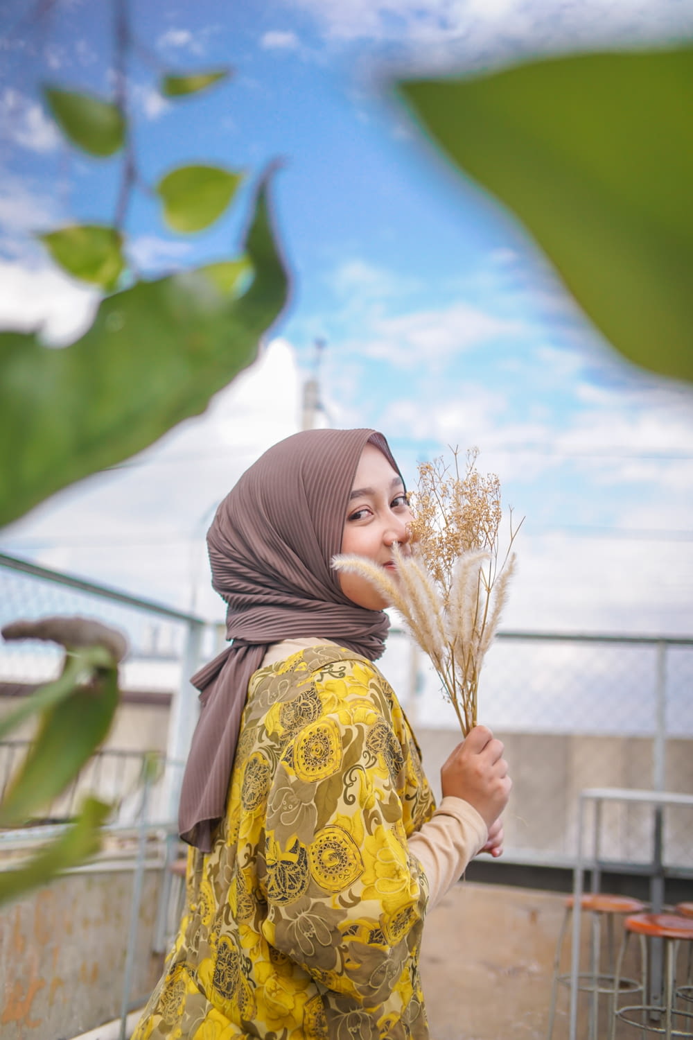 a woman in a hijab holding a bunch of flowers