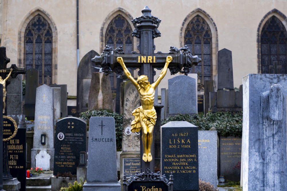 a statue of a woman holding a cross in a cemetery