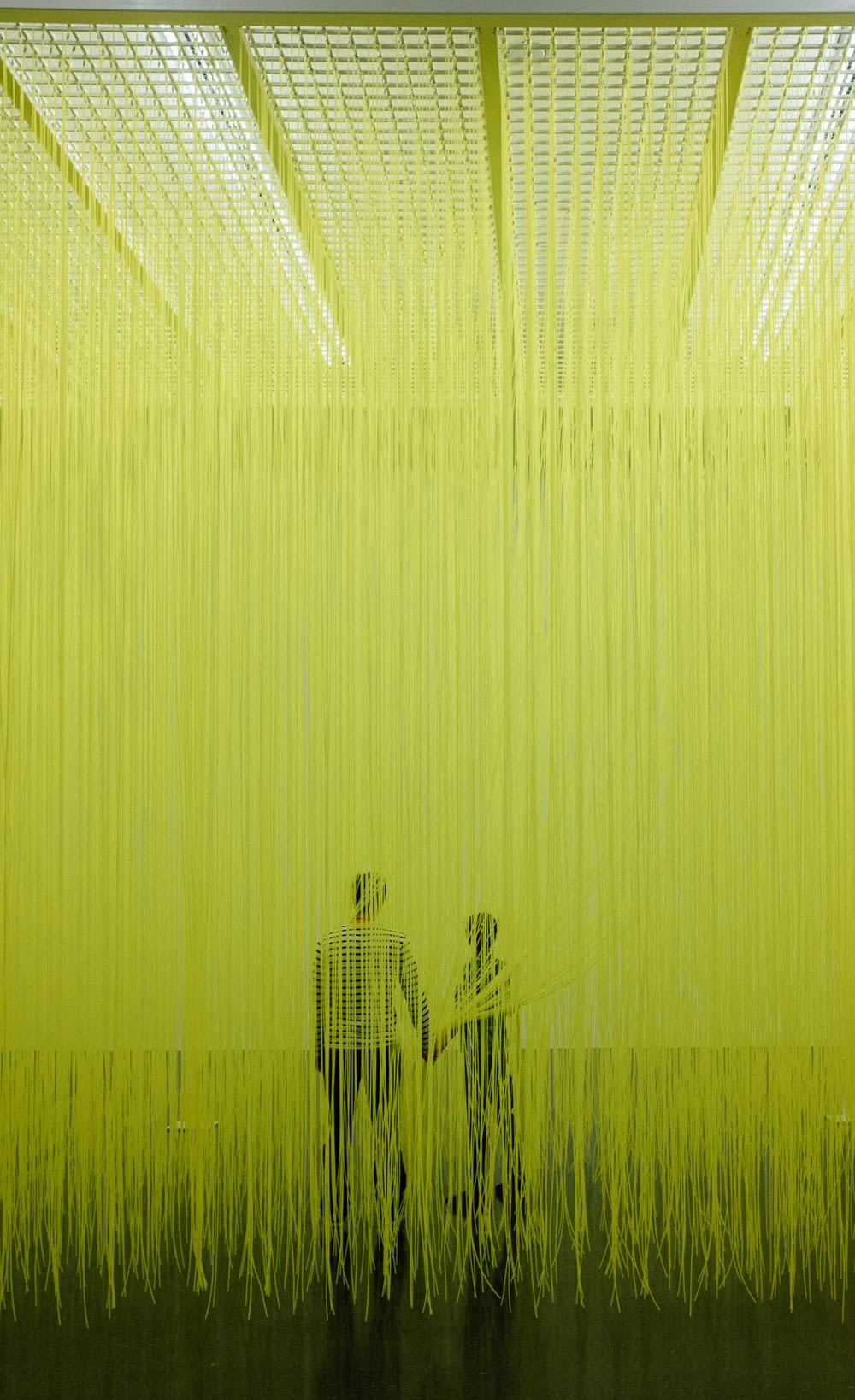 two people standing in front of a yellow curtain