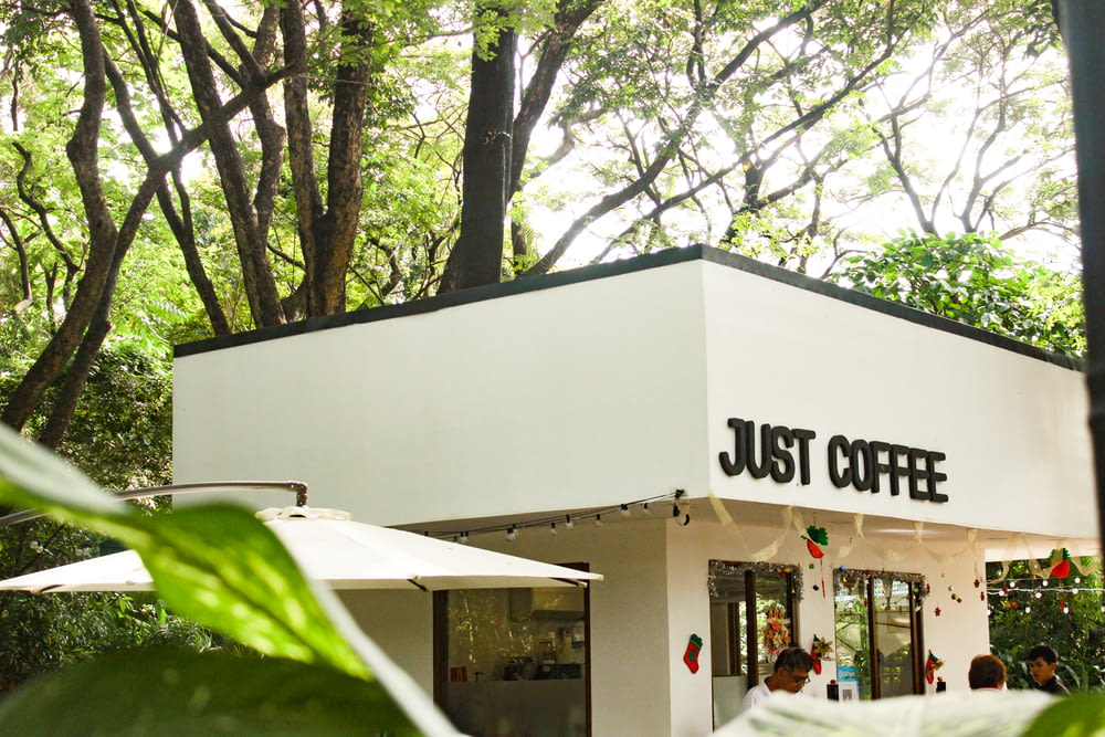 a white building with a sign that says just coffee