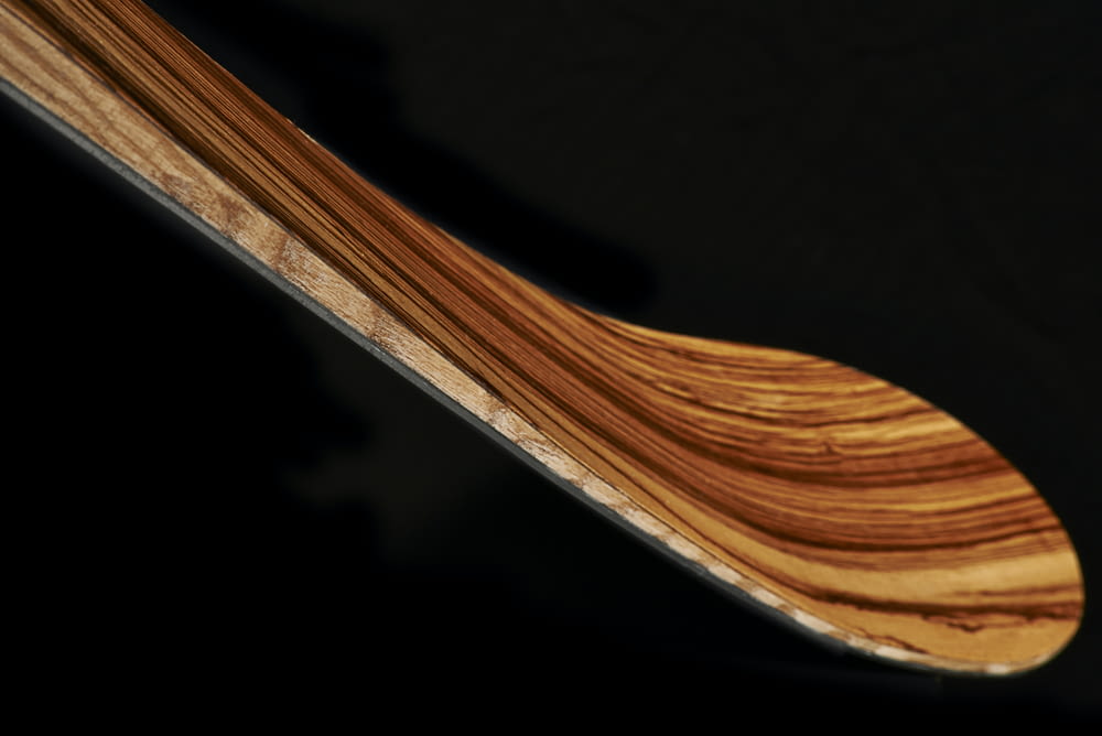 a close up of a wooden object on a black background