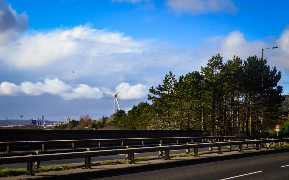 a highway with a wind turbine in the distance