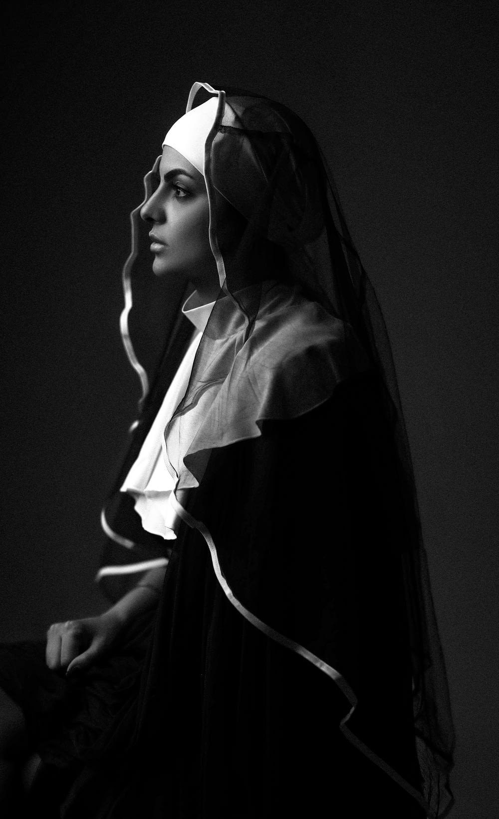 a black and white photo of a woman wearing a veil