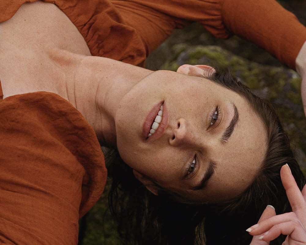 a woman laying on the ground with a peace sign in her hand