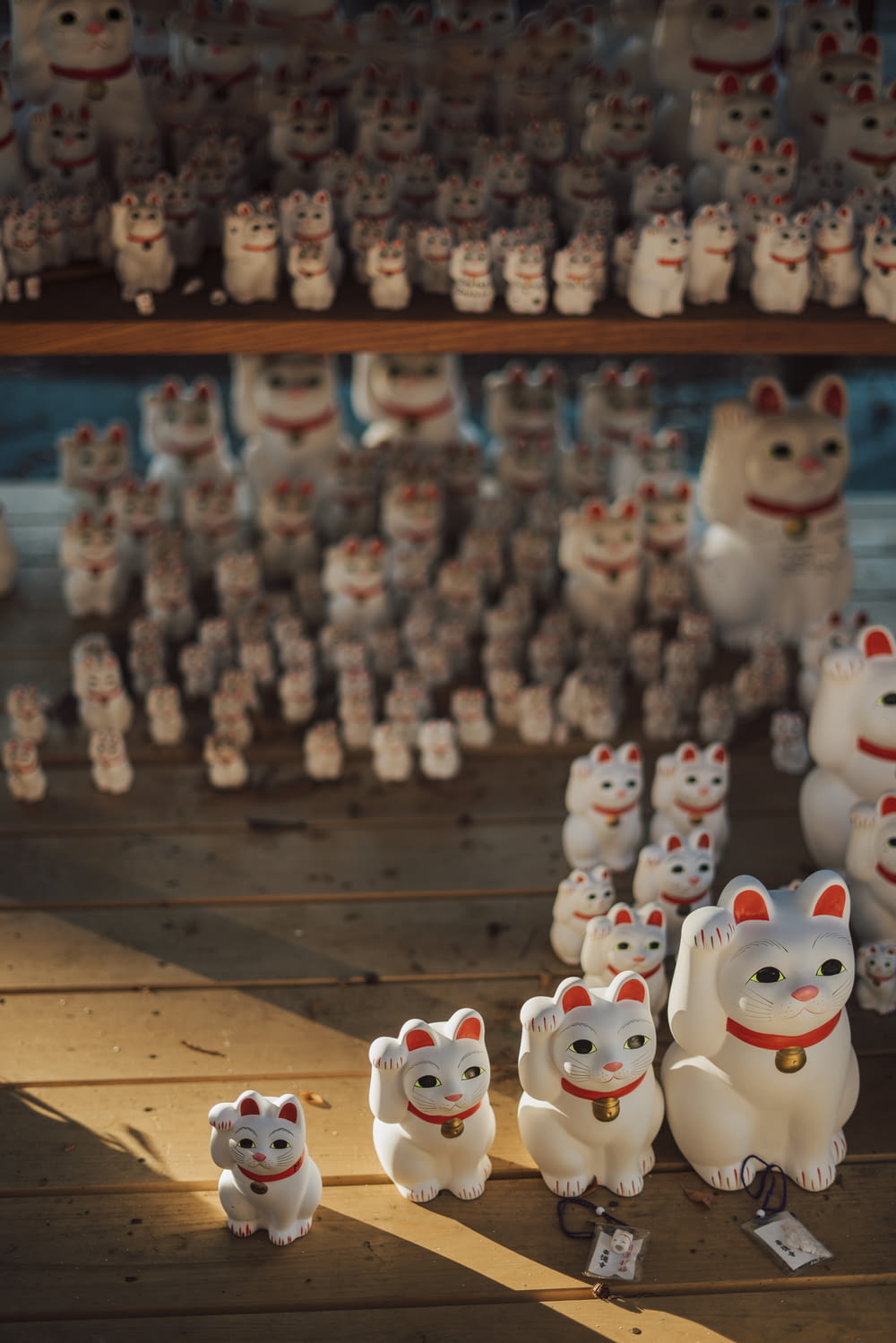 a group of white cat figurines sitting on top of a wooden floor