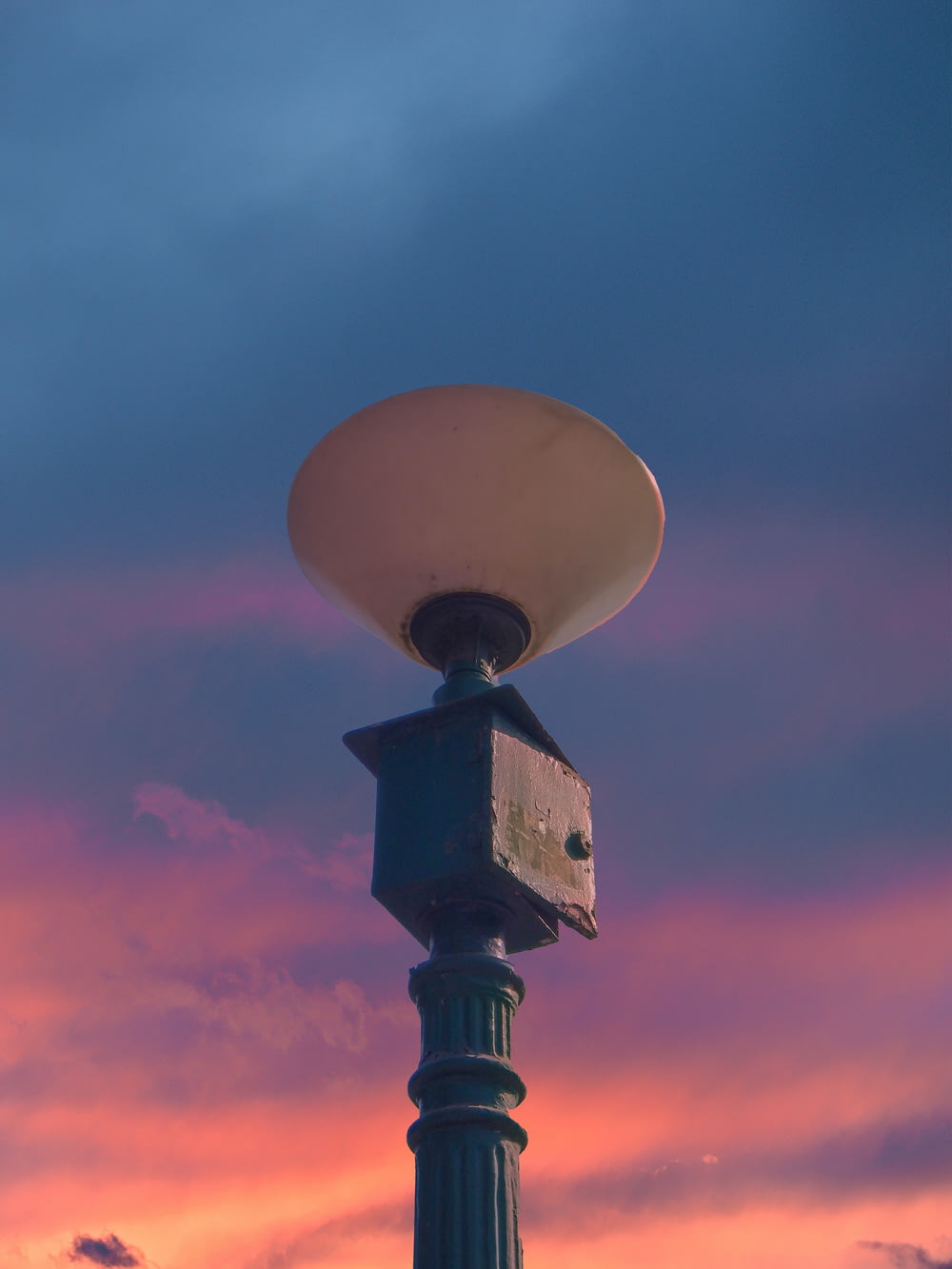 a lamp post with a bird house on top of it