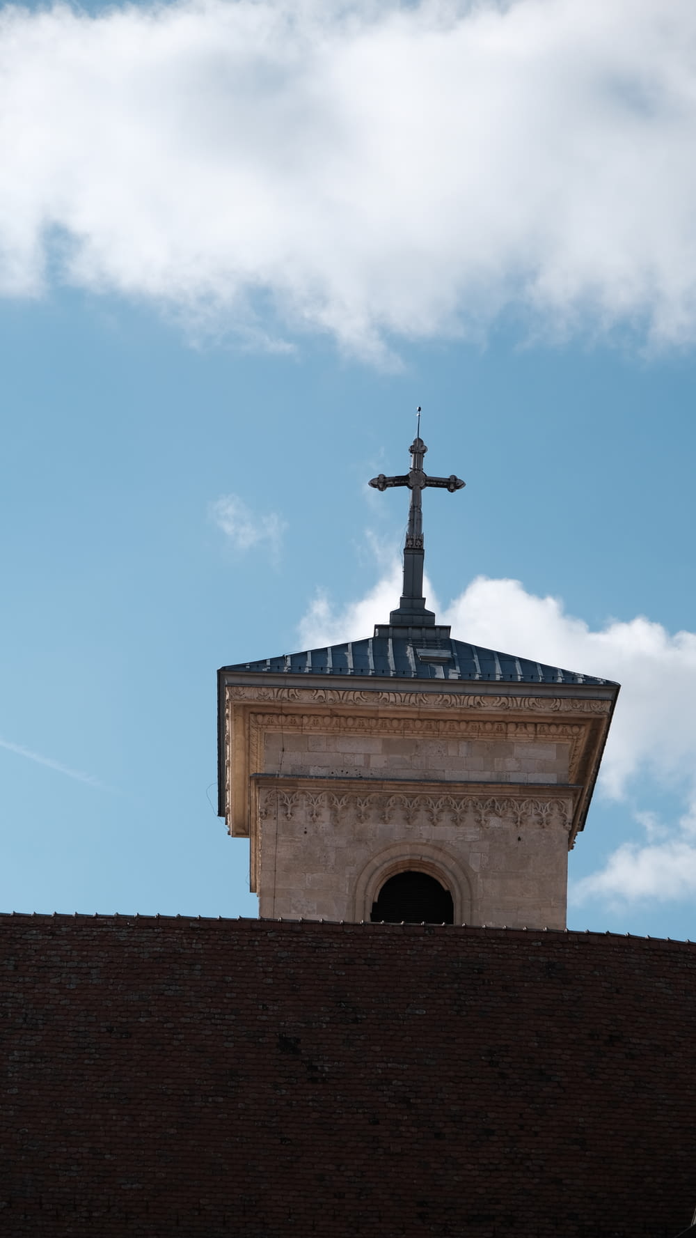 Una croce in cima a un edificio con uno sfondo del cielo