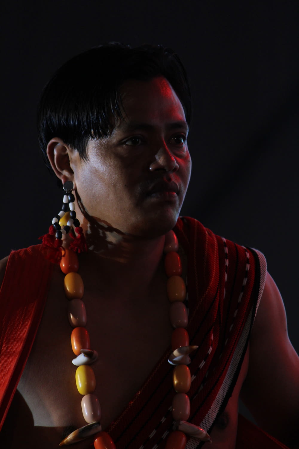 a man wearing a necklace and a necklace with beads